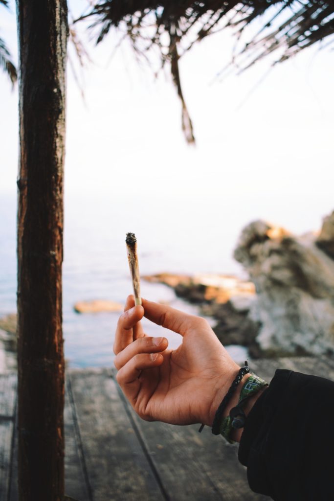 Lit joint on a wooden deck overlooking the ocean