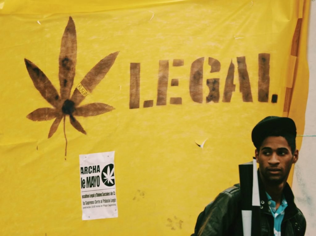 Man looking back, walking past Legal Marijuana art