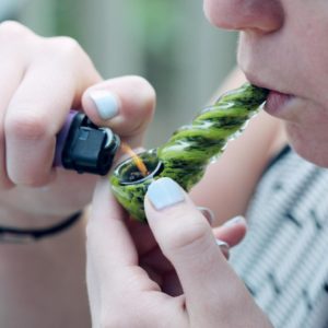 Lighting a cannabis pipe with crumbled hash