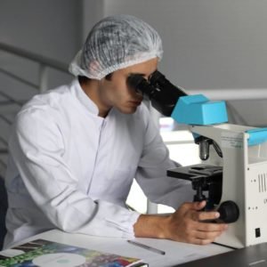 Researcher Looking into Microscope
